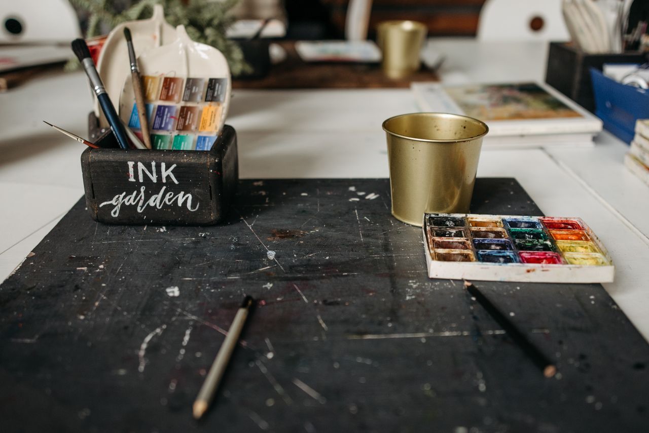 An art studio desk with brushes and watercolors showcasing a creative workspace.